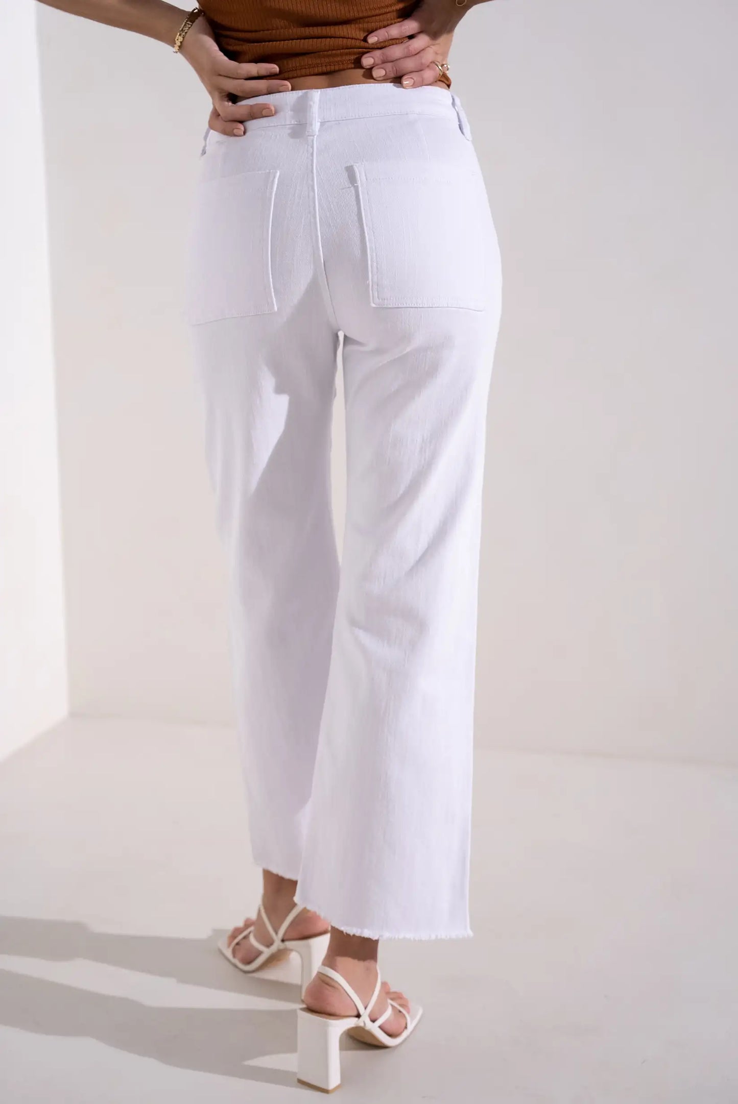 Pantalón blanco de mujer corte flare primavera, bolsillos traseros, sandalias de tacón