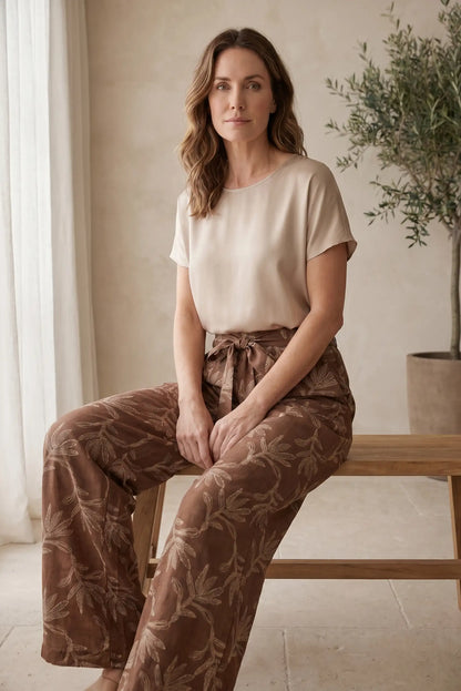 Mujer con camiseta beige y pantalones anchos estampados, moda casual cómoda y estilosa
