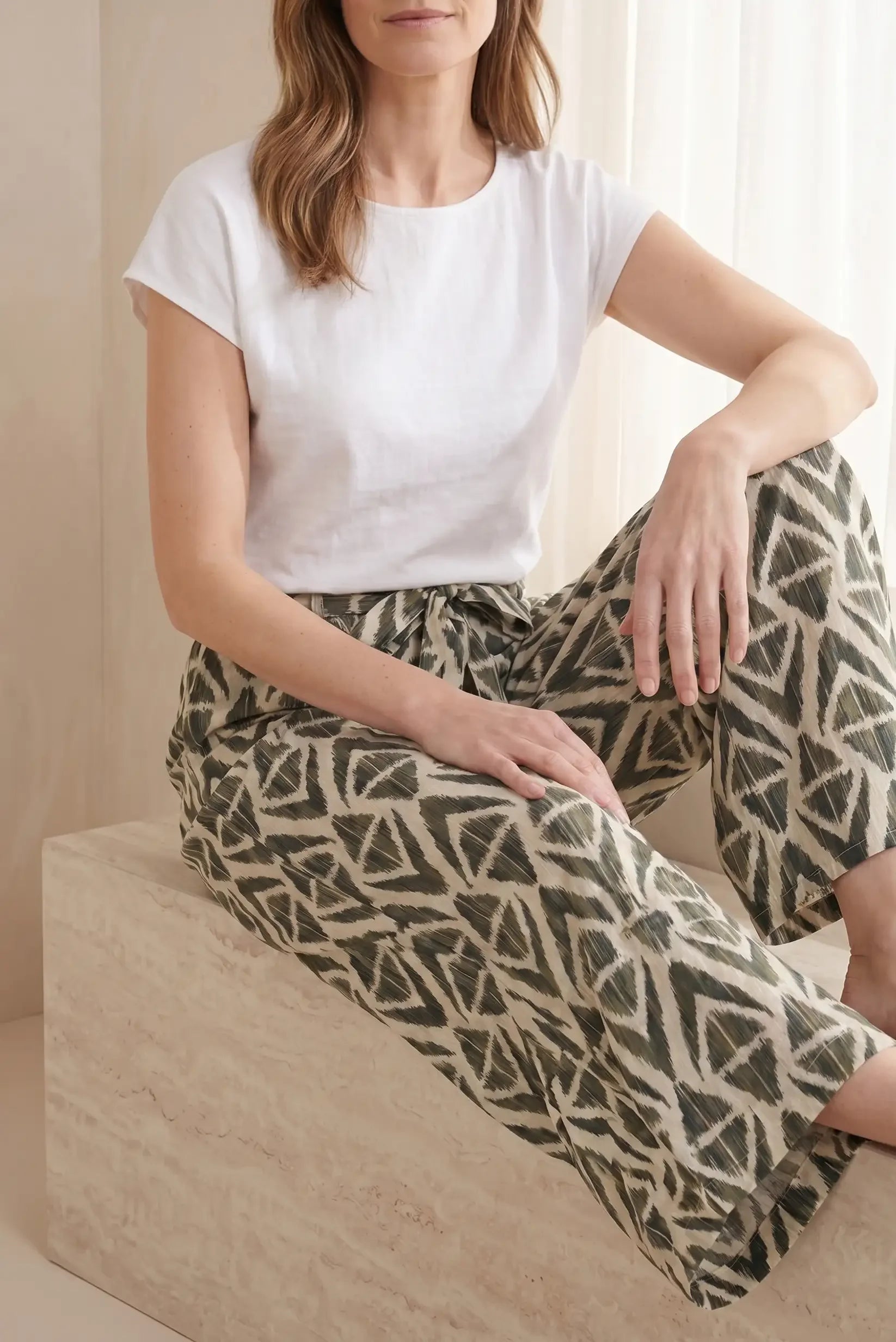 Mujer con camiseta blanca y pantalón ancho estampado geométrico, moda casual cómoda y estilosa