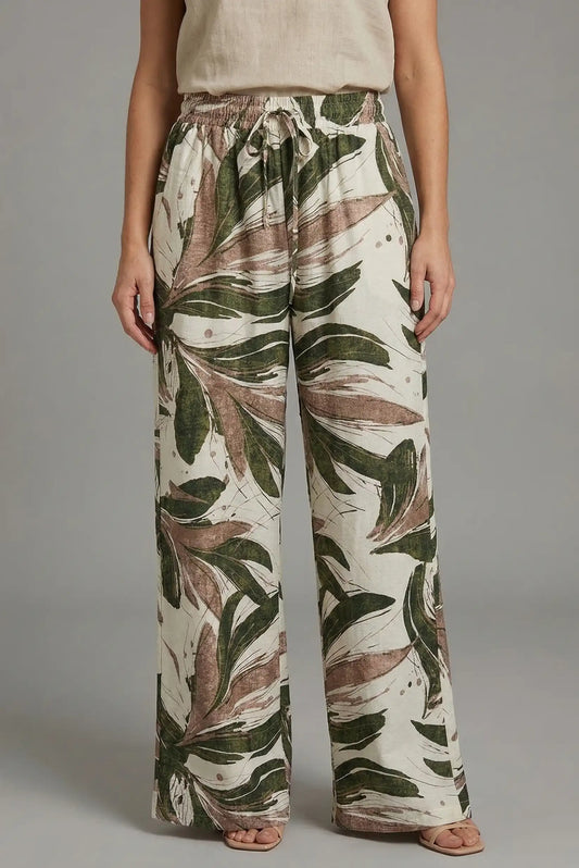 Pantalón fluido de mujer estampado hojas verde y marrón, estilo primavera casual.