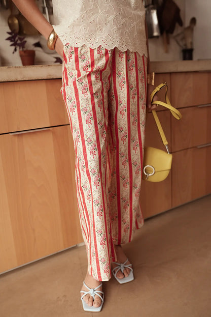 Pantalón largo fluido de mujer, estampado rojo con flores, estilo primaveral, en interior.