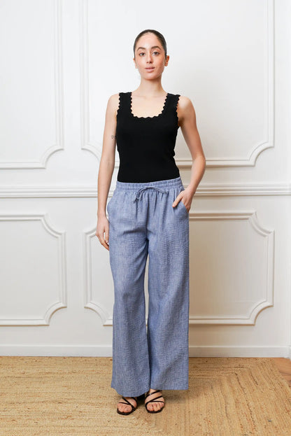 Mujer con pantalón largo azul de primavera y top negro, look casual femenino.