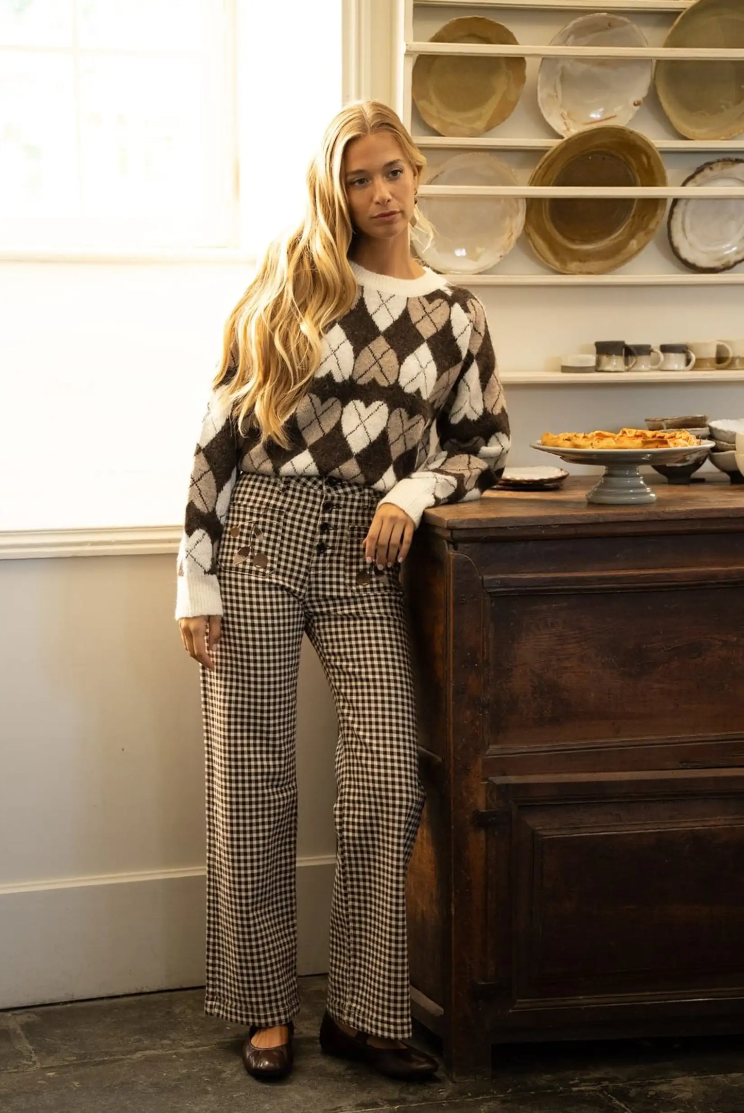 Mujer con jersey de punto a cuadros y corazones y pantalones vaqueros a cuadros, moda femenina otoño/invierno