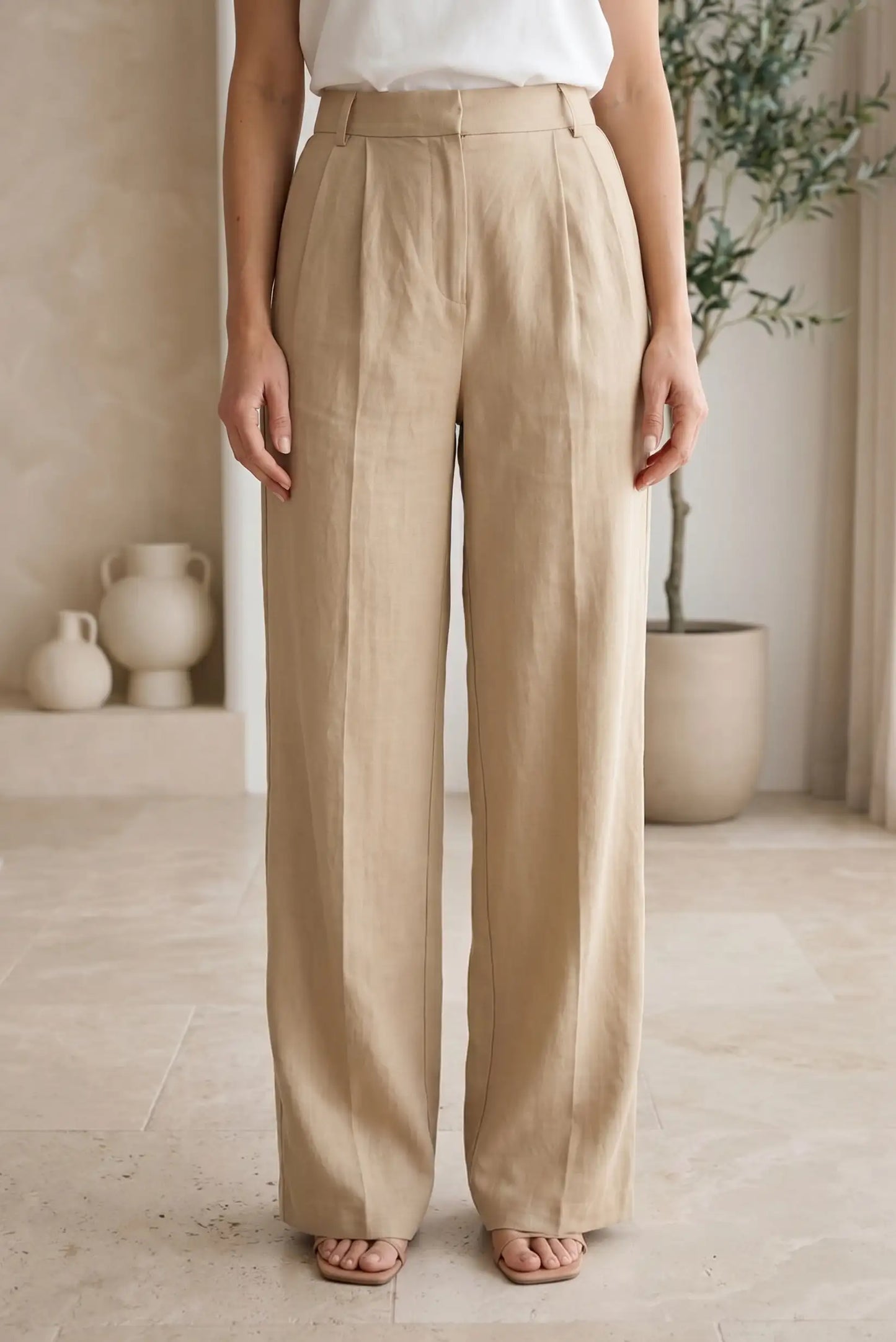 Pantalón largo fluido beige de mujer, corte recto, estilo casual, fondo neutro elegante