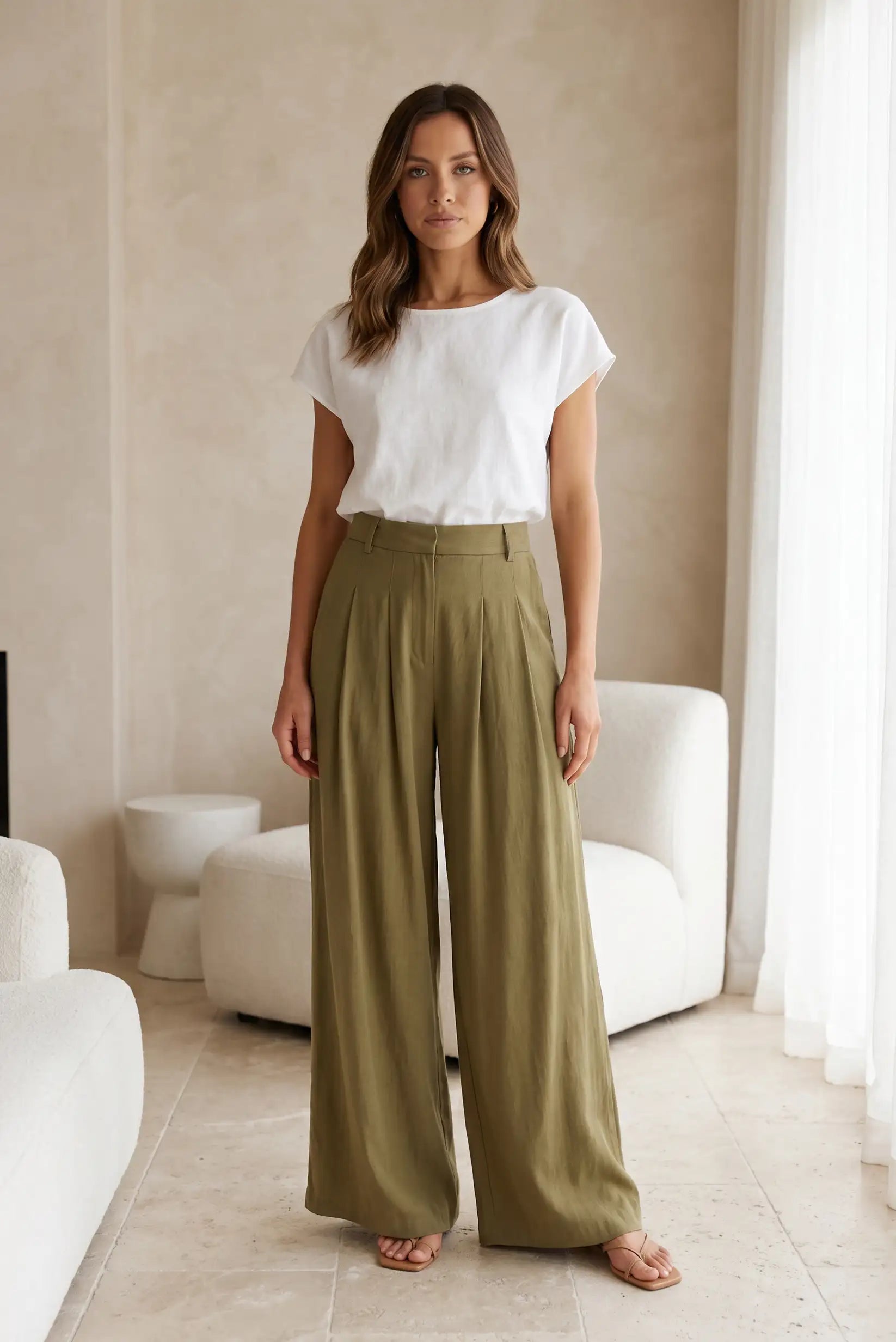 Mujer con pantalón fluido verde y camiseta blanca, moda casual femenina, interior elegante