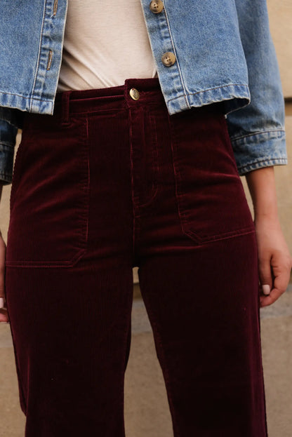 Pantalón largo de micropana burdeos para mujer, combinado con chaqueta vaquera azul