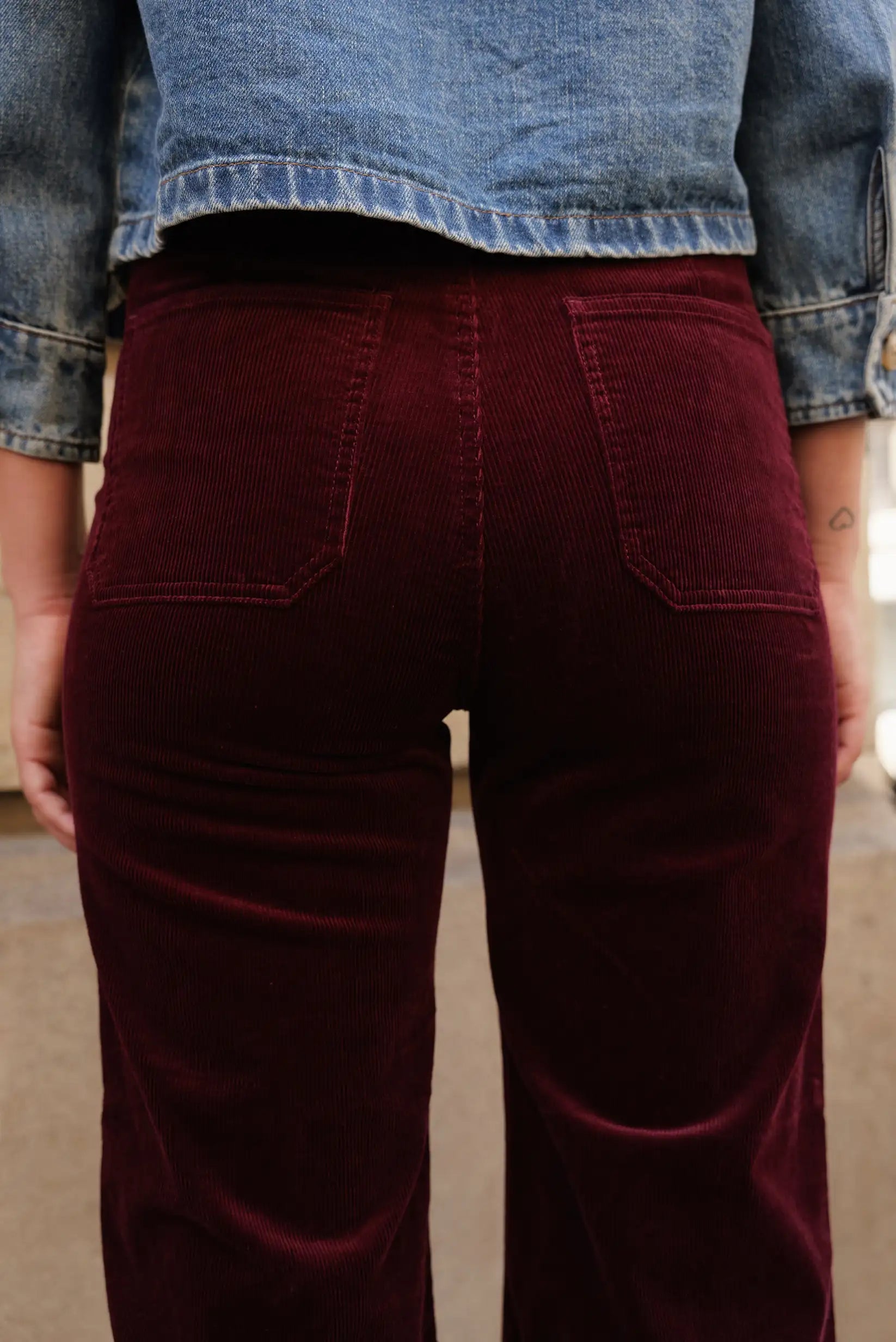 Pantalón largo de micropana color burdeos para mujer con chaqueta de mezclilla azul