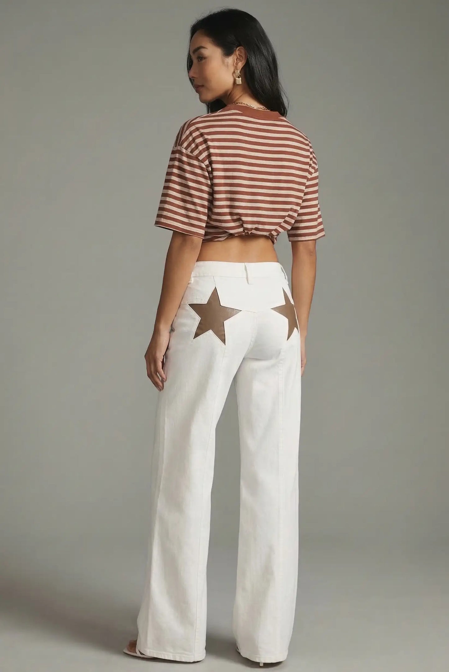 Pantalón vaquero blanco de mujer con estrellas marrones en la parte trasera, estilo casual.