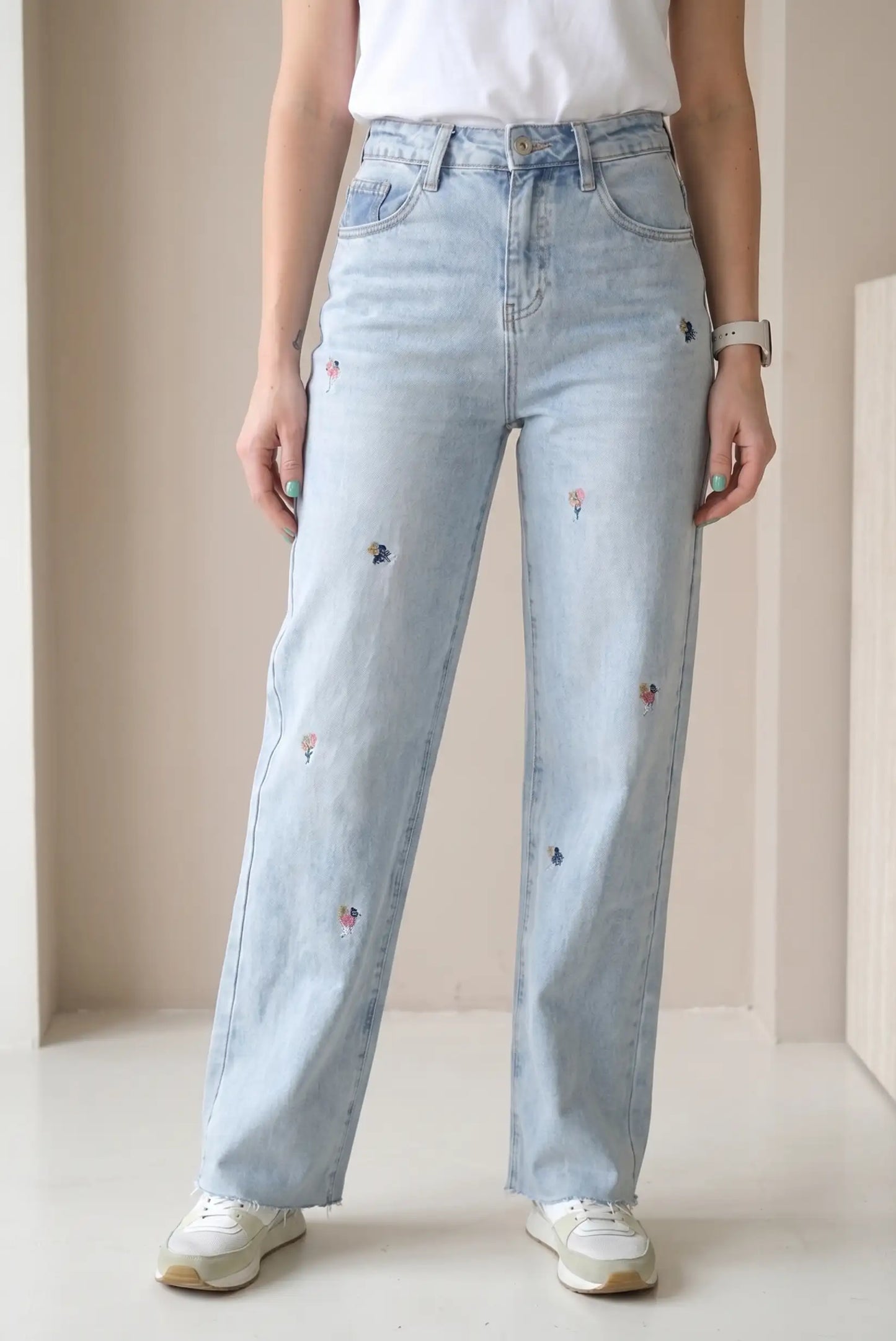 Pantalón vaquero largo de mujer, azul claro, con bordados florales pequeños y corte recto.