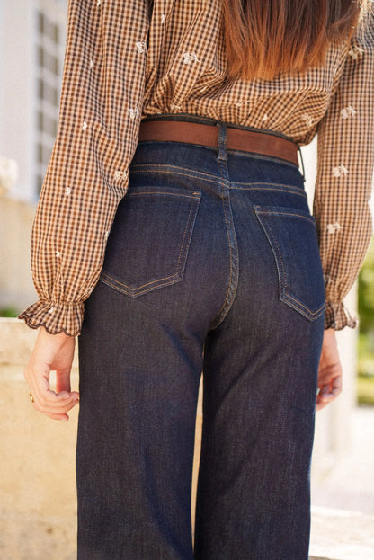 Jeans vaqueros azul oscuro con cinturón marrón y blusa cuadros marrones, moda femenina