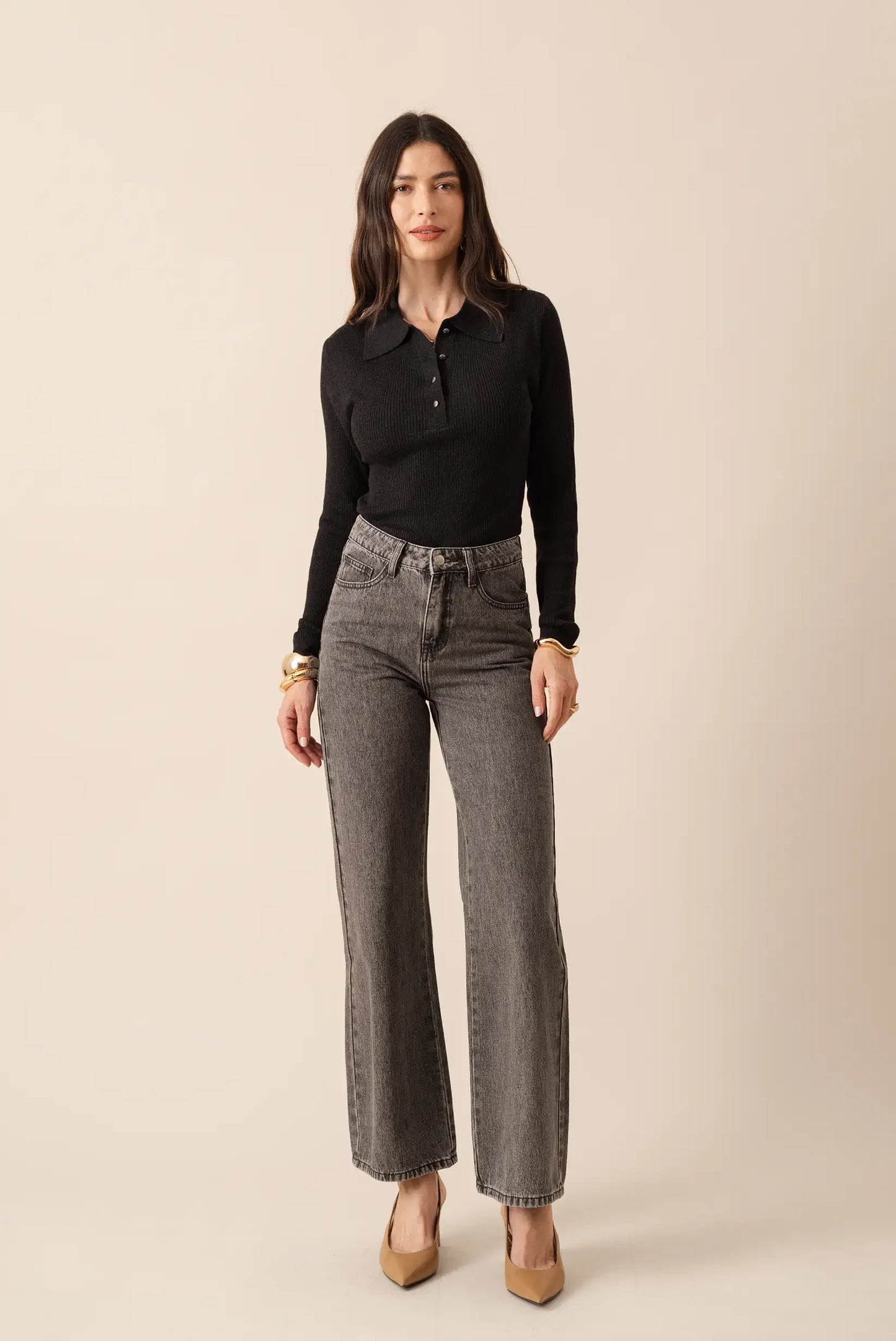 Jeans grises anchos con camisa negra de cuello polo y tacones beige, moda femenina elegante y casual