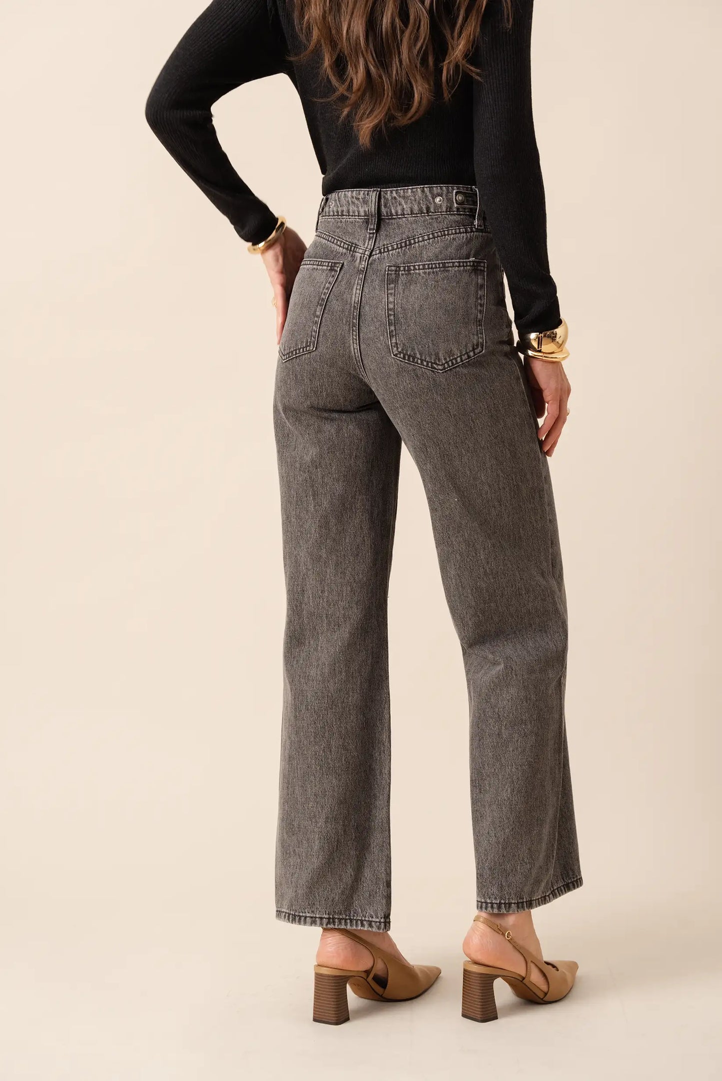 Jeans grises de corte ancho con top negro y tacones marrones, moda femenina elegante