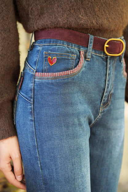 Vaqueros azules con bolsillo decorado con corazón rojo y cinturón marrón, moda femenina