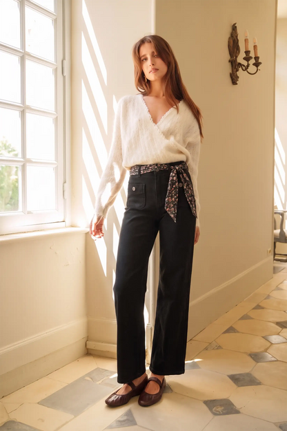 Mujer con suéter blanco y pantalones negros de moda femenina, estilo elegante y cómodo