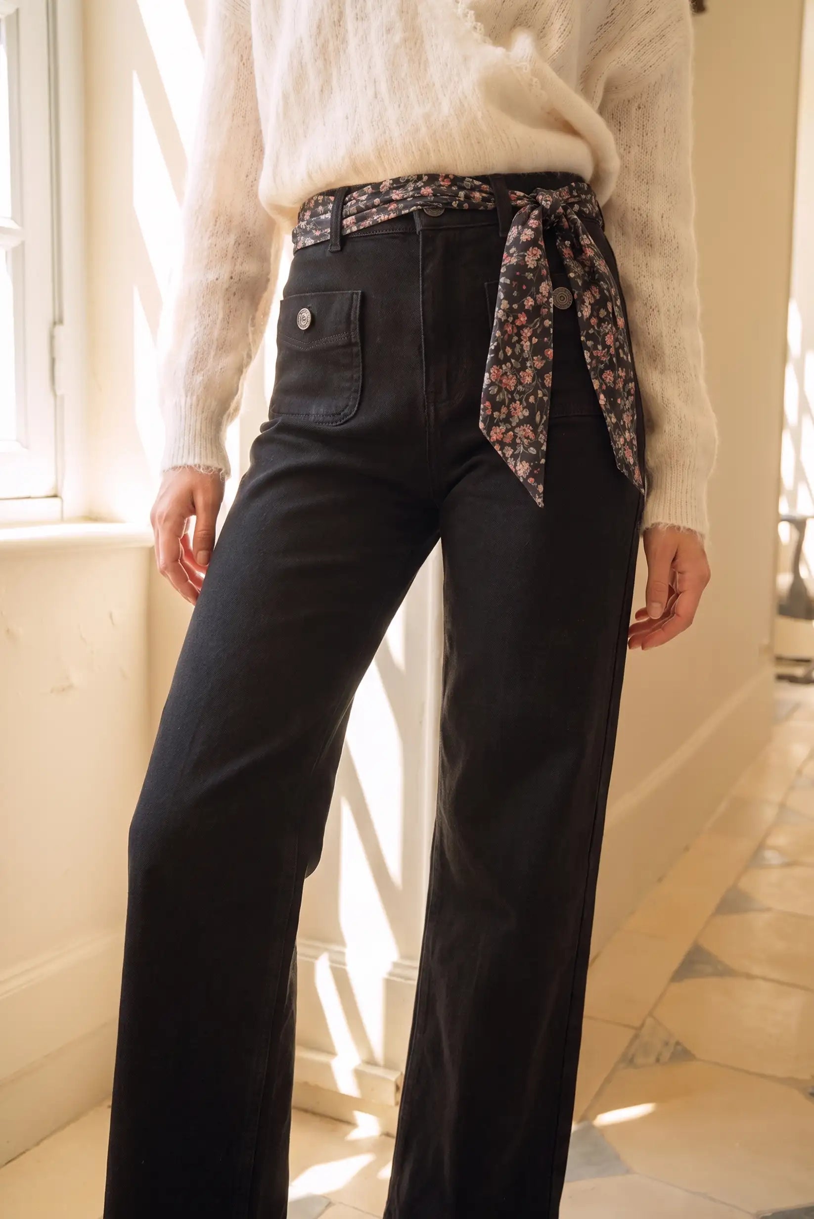 Pantalón negro de corte ancho con cinturón floral, ideal para moda femenina y looks elegantes