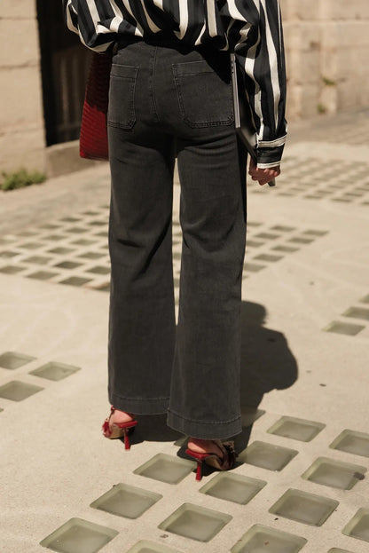 Pantalones vaqueros anchos negros con camisa a rayas y sandalias rojas, moda urbana femenina