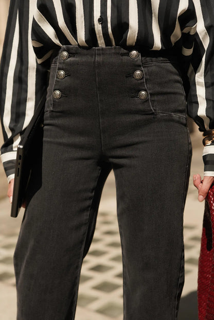 Pantalón vaquero negro con botones decorativos y camisa a rayas, moda femenina elegante y urbana