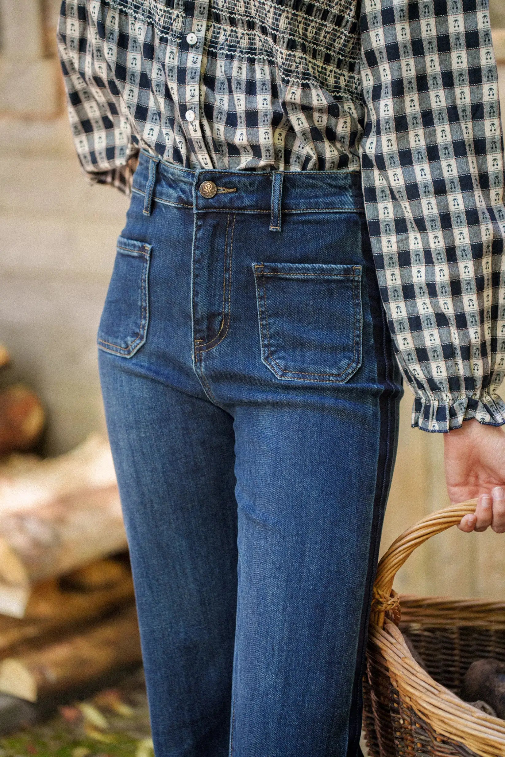 Jeans azul oscuro con bolsillos traseros y camisa a cuadros, moda femenina casual con cesta de mimbre