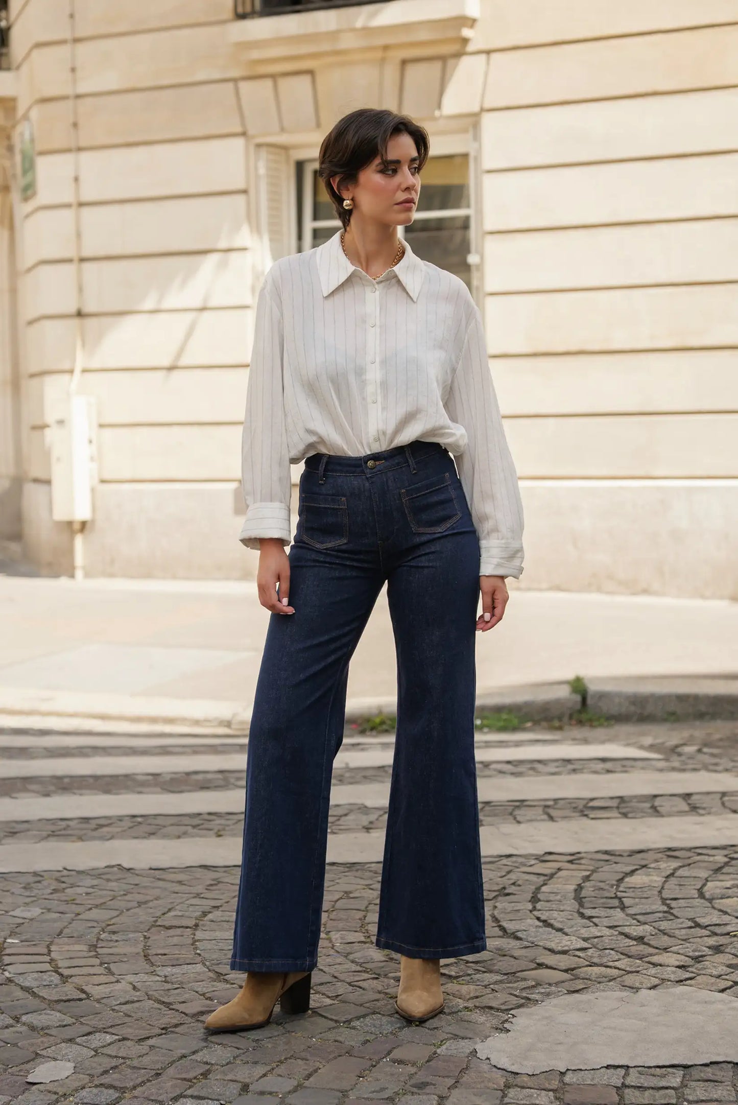 Camisa blanca a rayas con jeans vaqueros anchos y botines marrones, moda femenina urbana