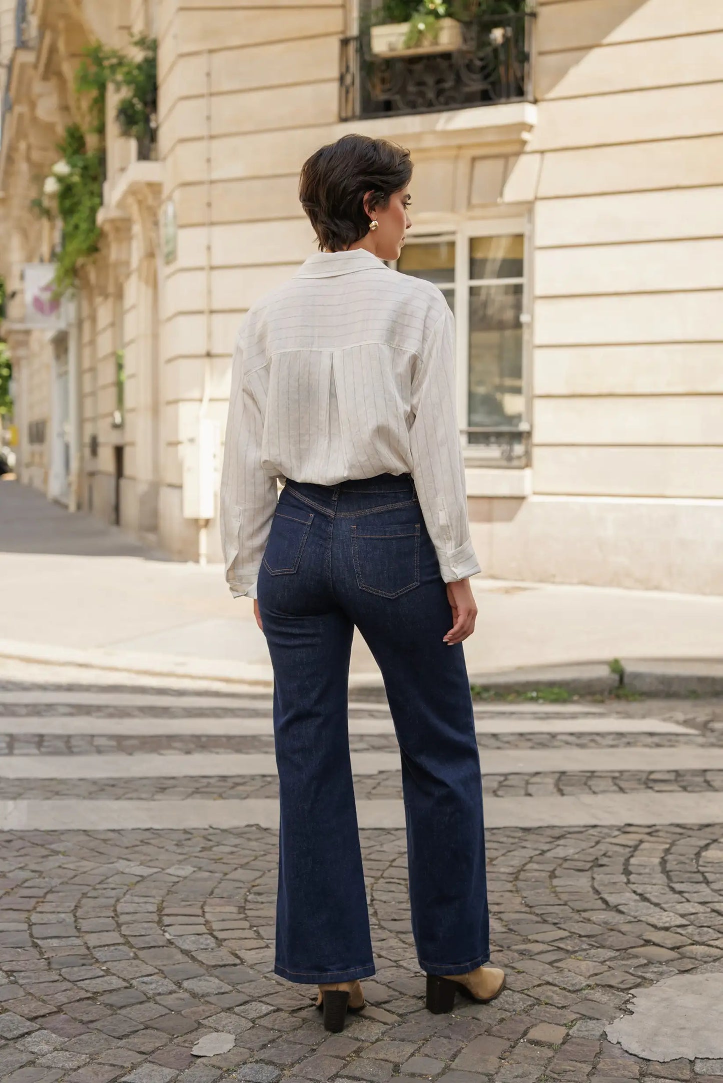 Jeans vaqueros anchos azul oscuro con camisa blanca a rayas, ideal para moda femenina urbana y casual