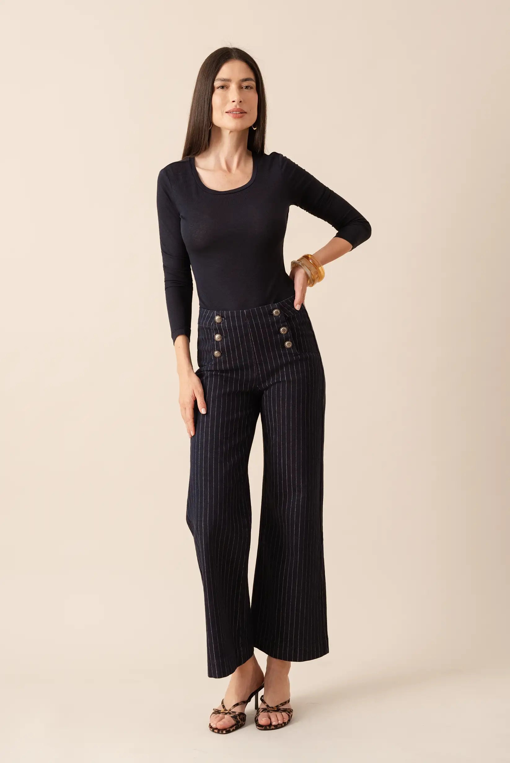 Pantalones anchos a rayas con botones, camiseta negra y sandalias de leopardo para mujer