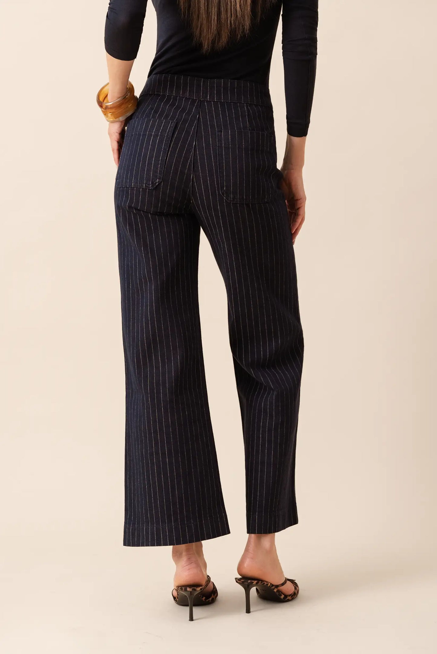 Pantalones anchos a rayas verticales, corte recto y bolsillos traseros, ideal para look casual o de oficina.