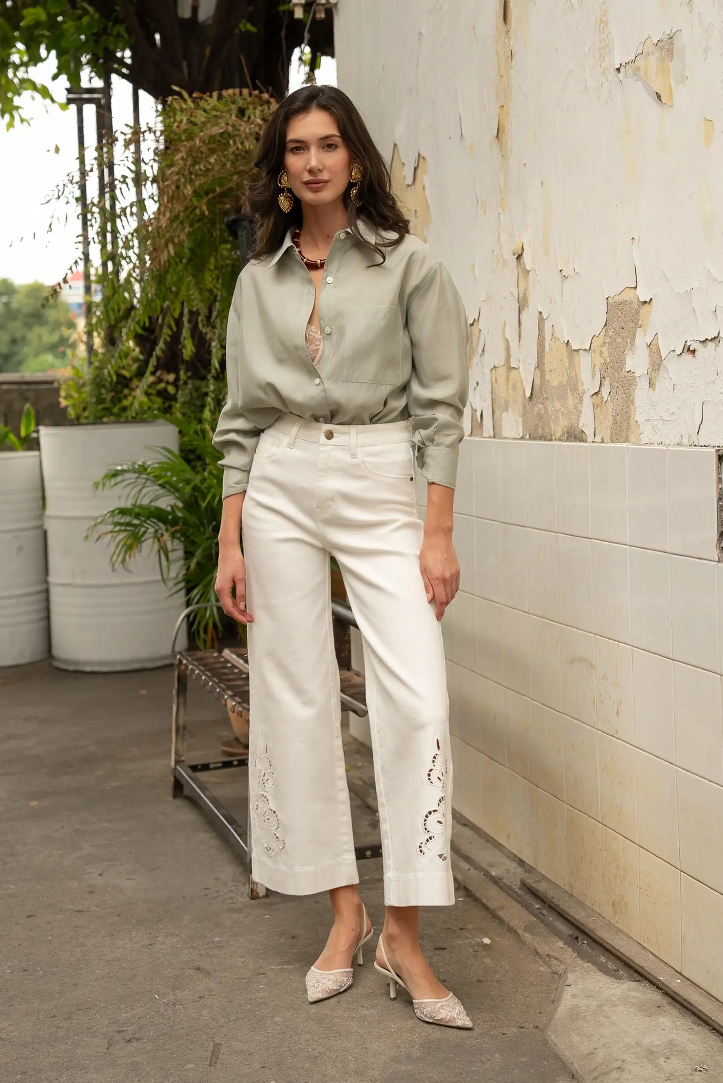 Mujer con camisa beige y pantalón largo blanco calado, look casual de moda femenina.