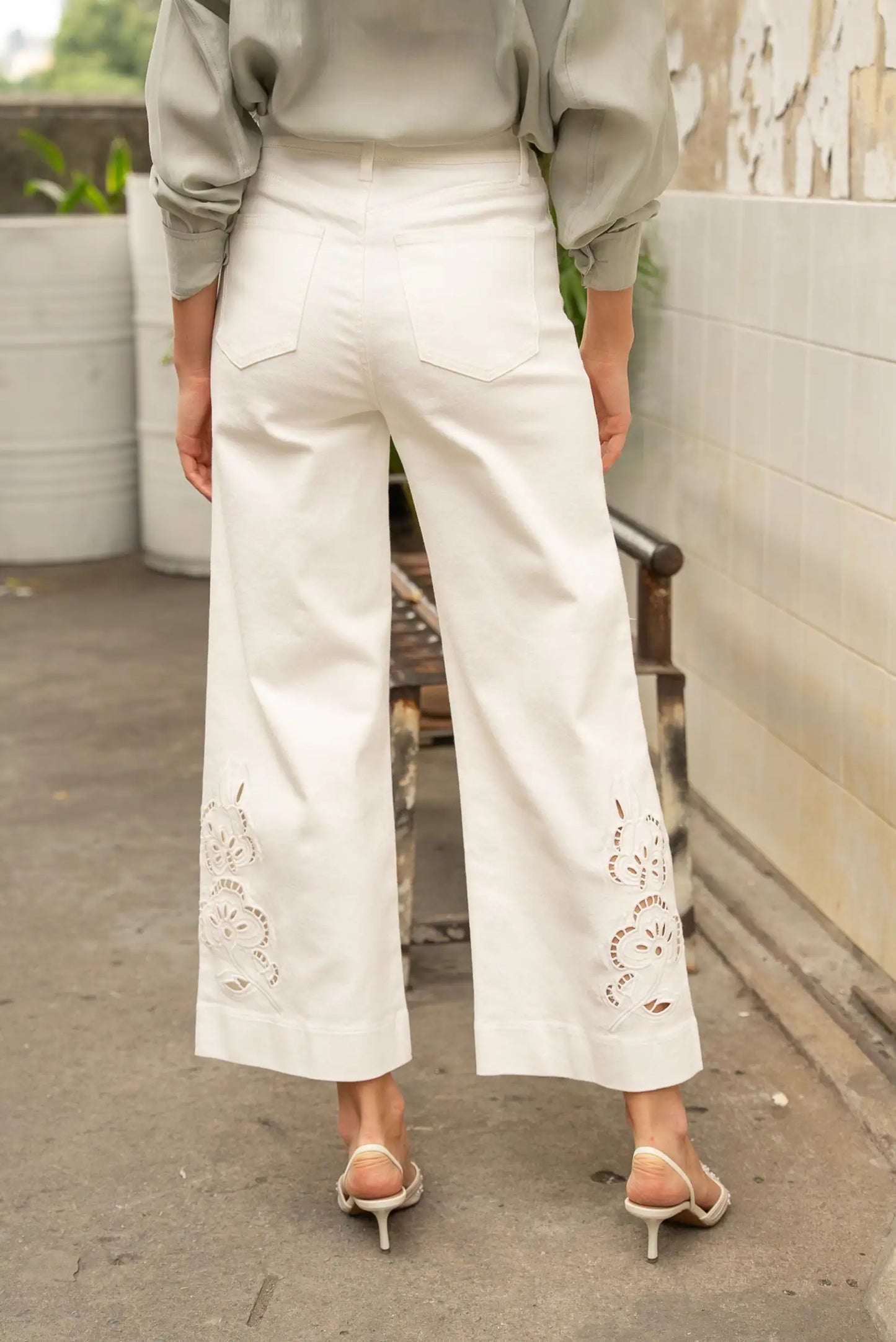 Pantalón blanco de mujer tipo palazzo con bordados florales en las piernas, estilo casual