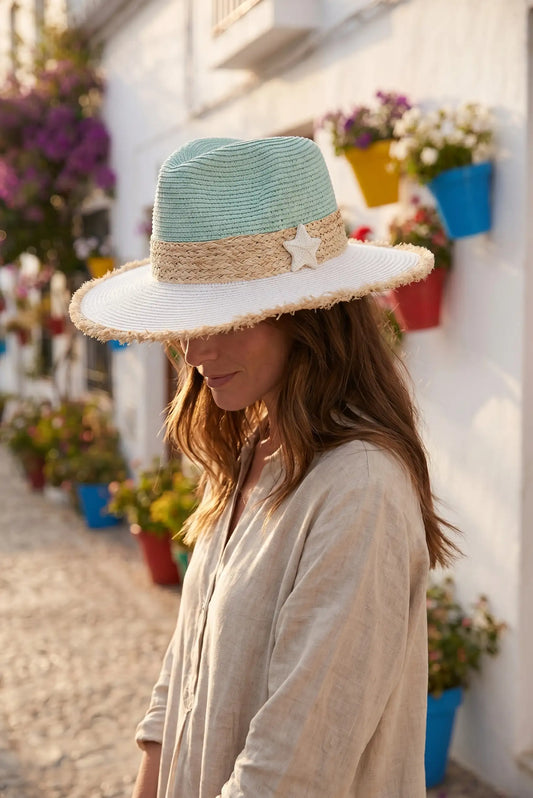 Sombrero de paja con estrella marina, ideal para looks casuales de verano y paseos en calles blancas con flores.