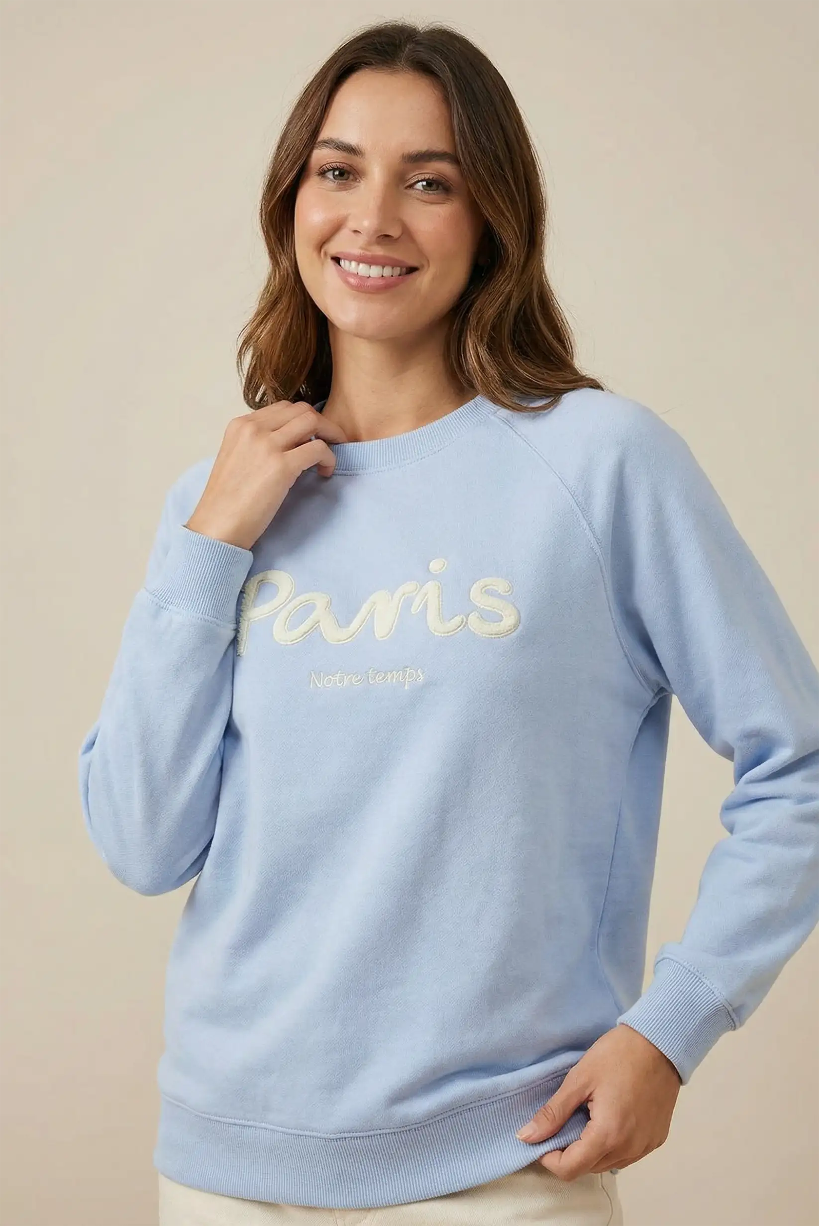 Mujer con sudadera azul pastel 'Paris', moda casual CHICA del Sur, fondo neutro.