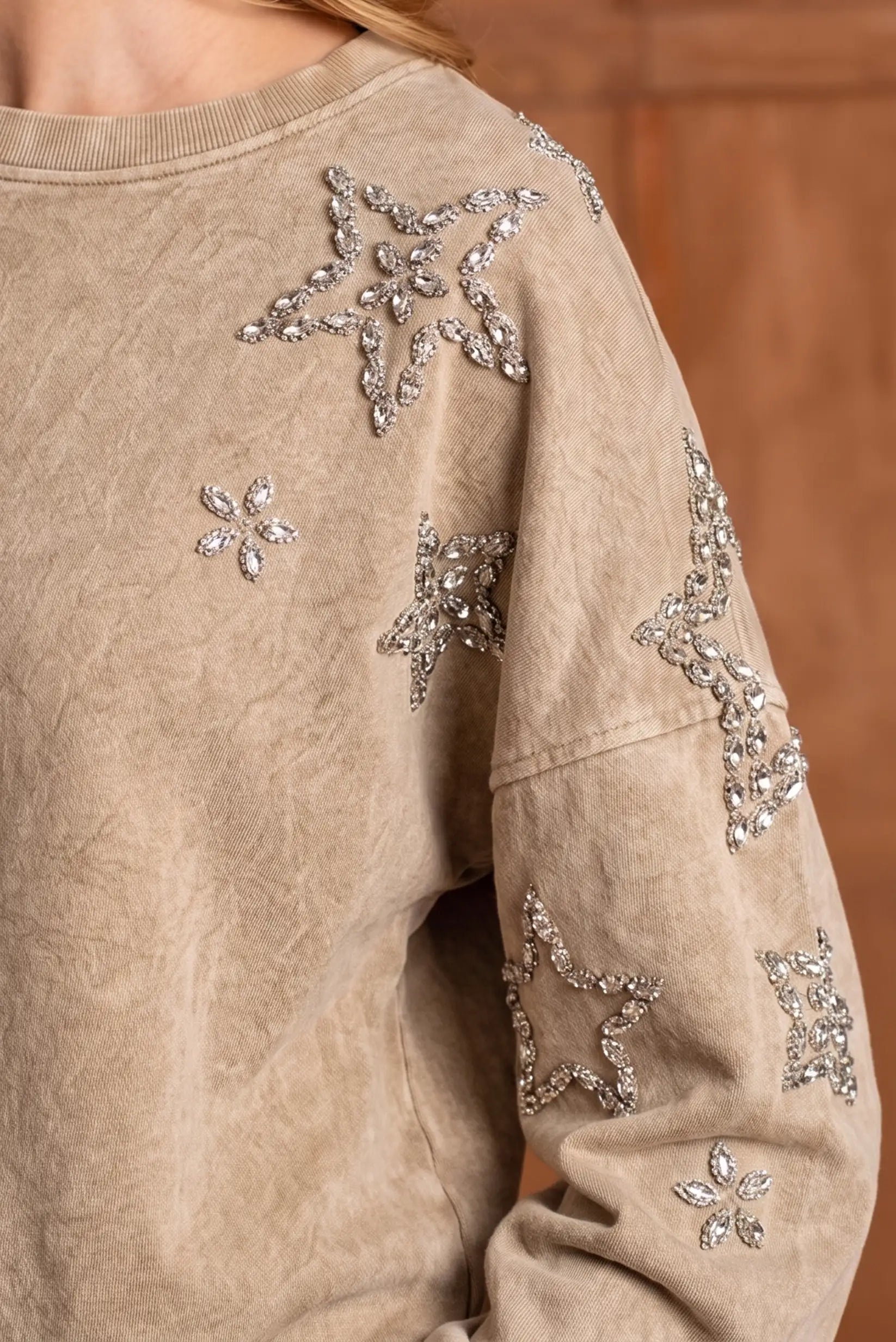 Sudadera beige texturizada con estrellas y flores bordadas en pedrería brillante