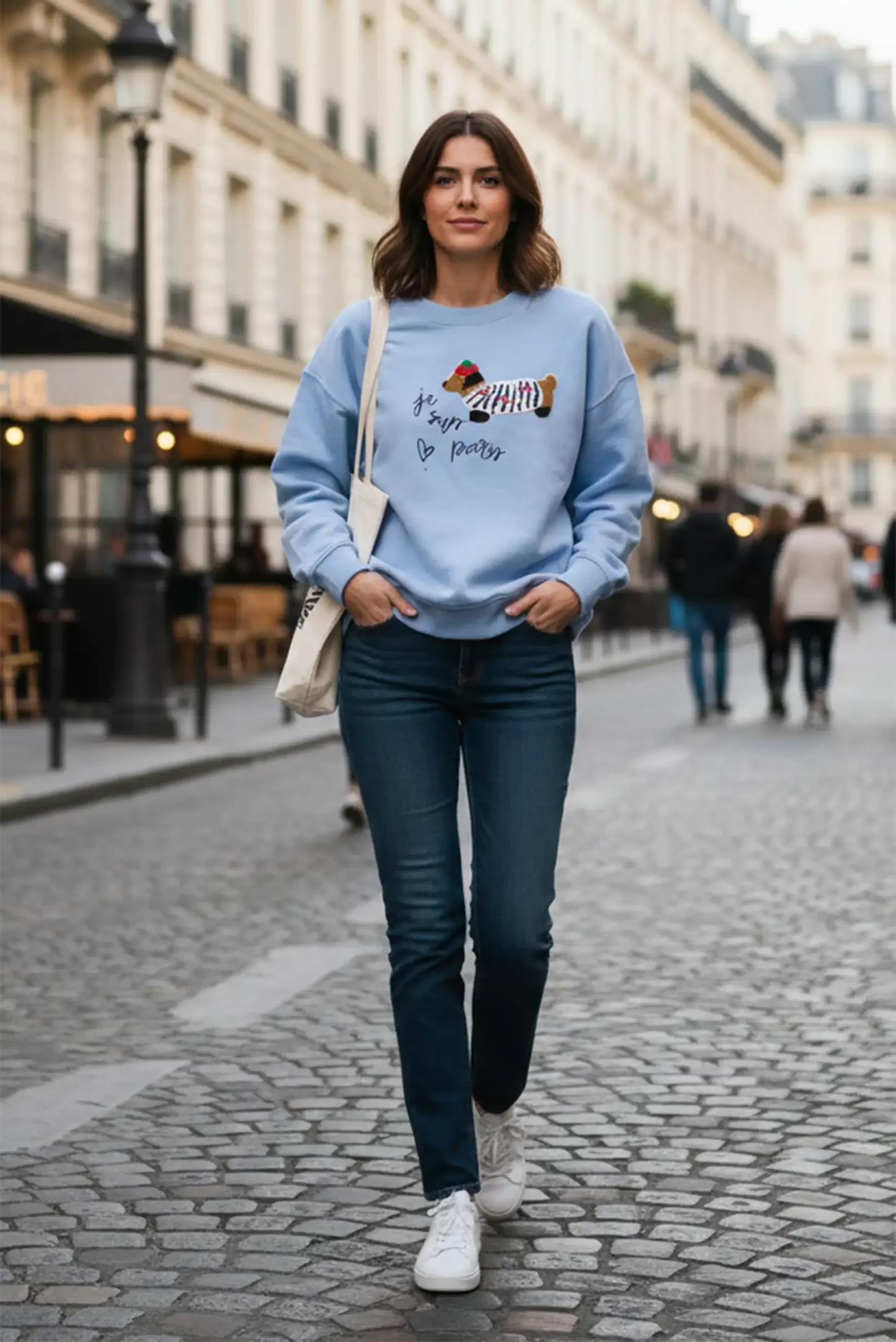 Mujer con sudadera azul claro de perro salchicha y jeans, moda casual CHICA del Sur en calle urbana.