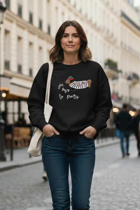 Mujer con sudadera negra de perro salchicha y texto 'je suis paris', look casual CHICA del Sur en calle urbana.