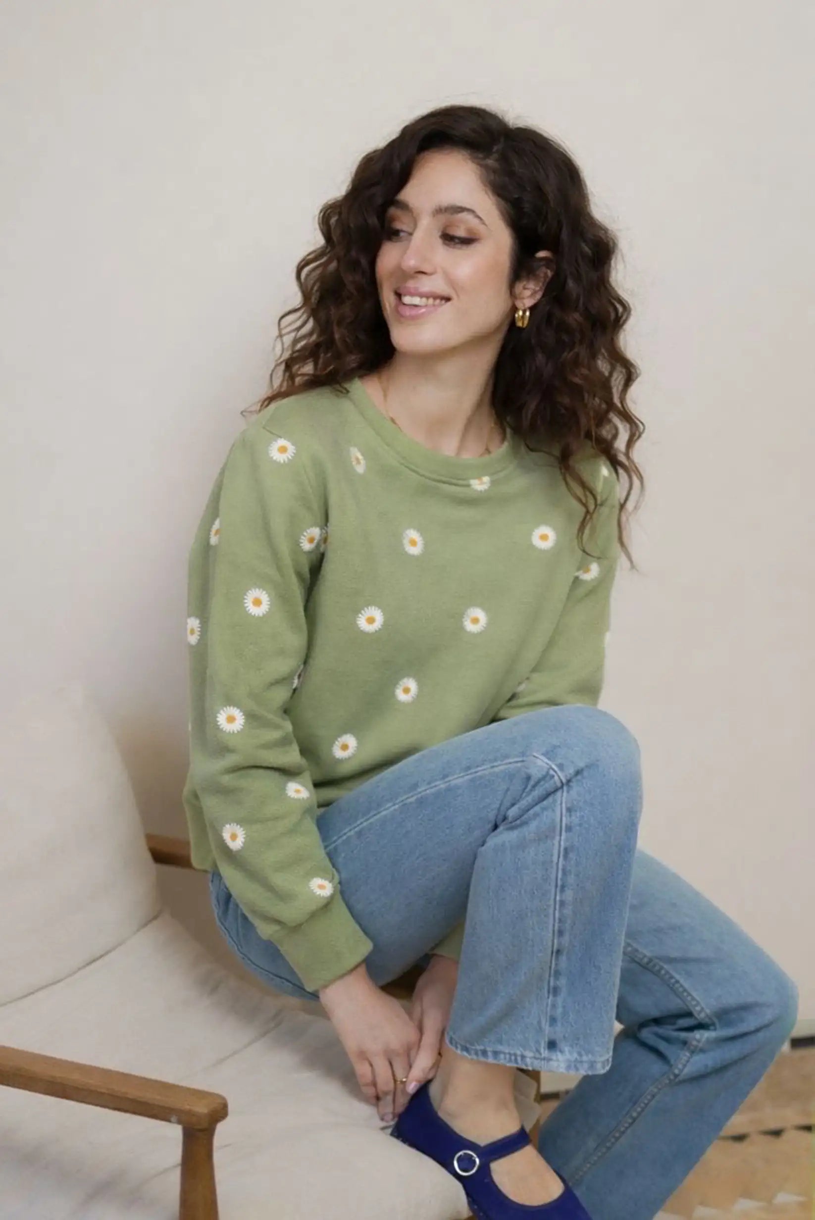 Mujer con sudadera verde con estampado de margaritas, jeans y zapatos azul, moda casual CHICA del Sur