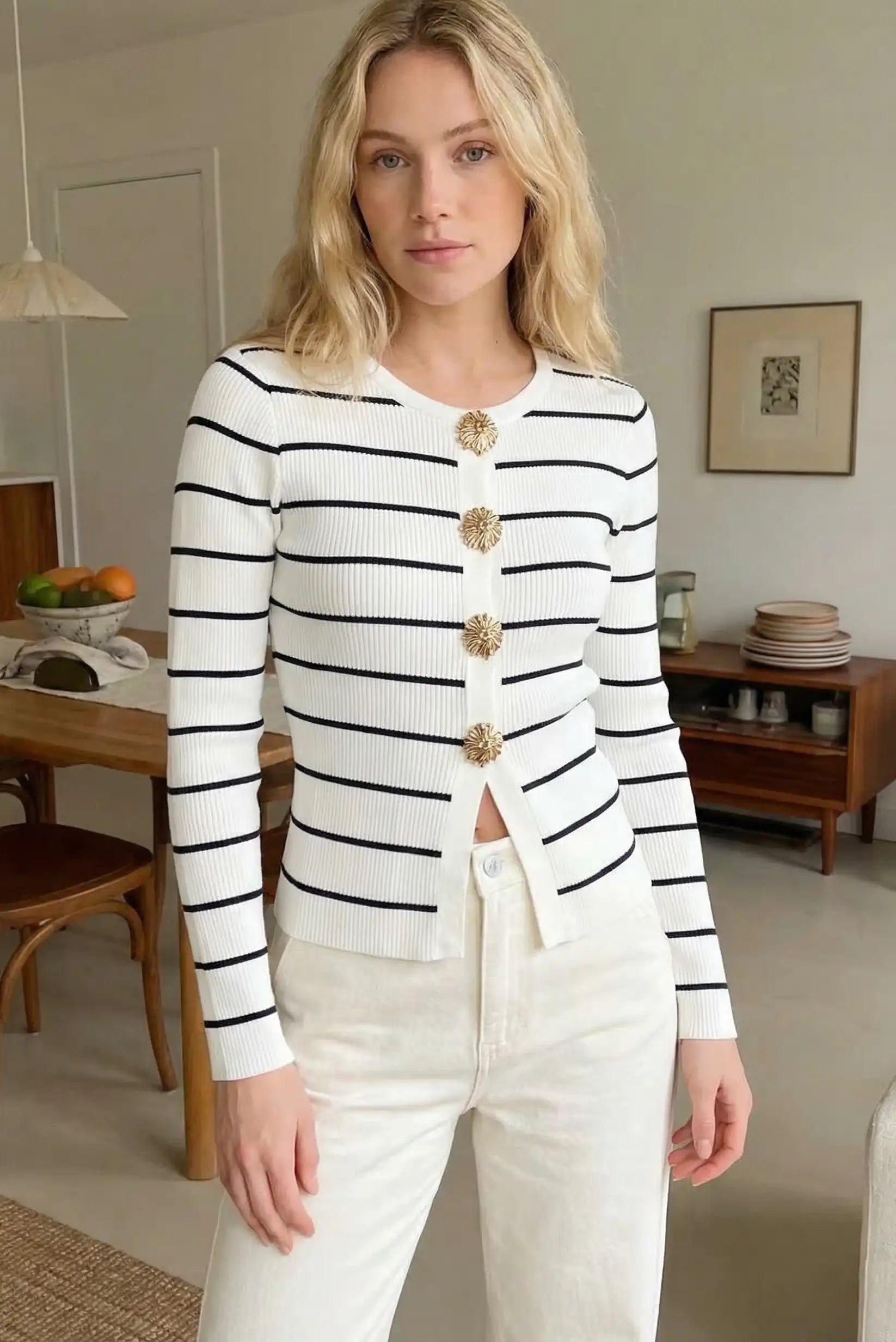 Mujer con suéter blanco de rayas negras y botones dorados, look casual de primavera.