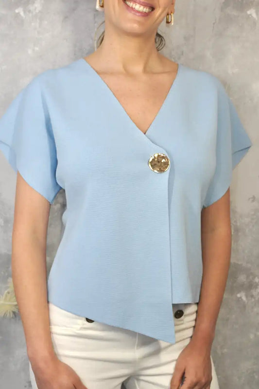 Top azul cielo cruzado de punto con botón dorado – Elegancia primavera/verano