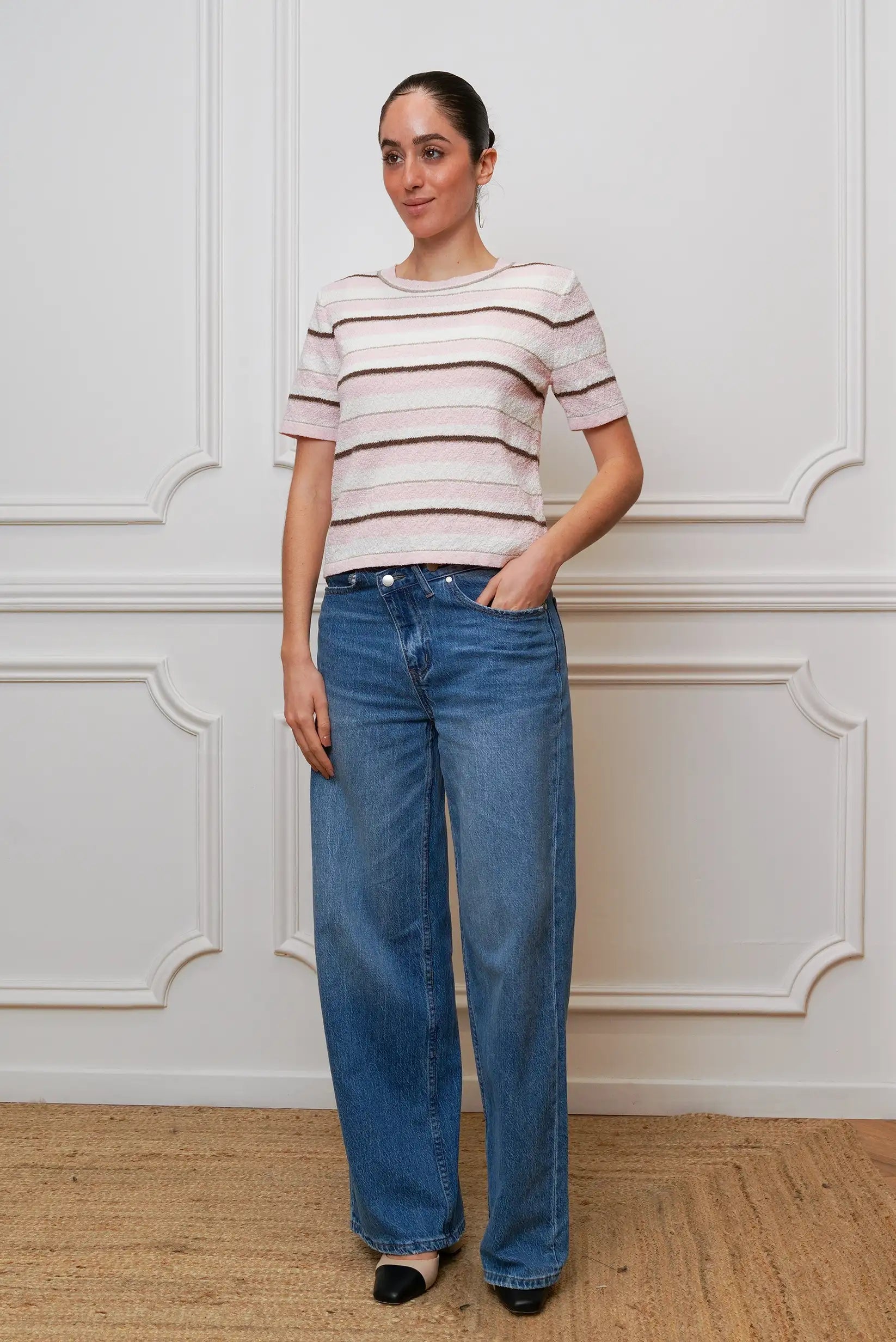 Mujer con camiseta de rayas rosa y marrón de manga corta y pantalón vaquero ancho