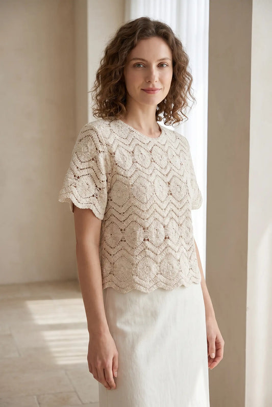 Blusa de encaje beige con mangas cortas y cuello redondo, ideal para looks casuales y estilosos.