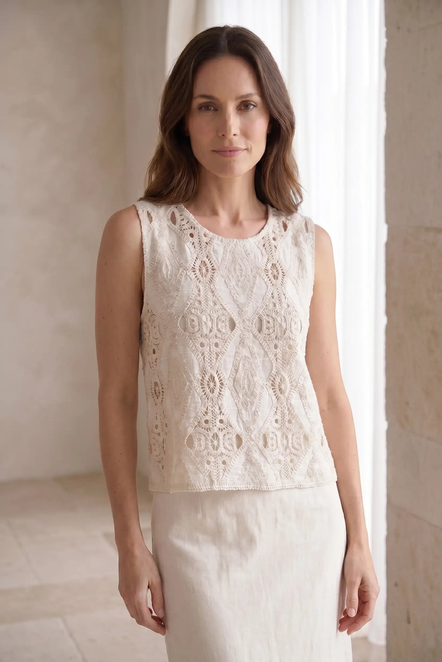 Blusa sin mangas blanca con encaje geométrico, ideal para looks casuales y estilosos de mujer
