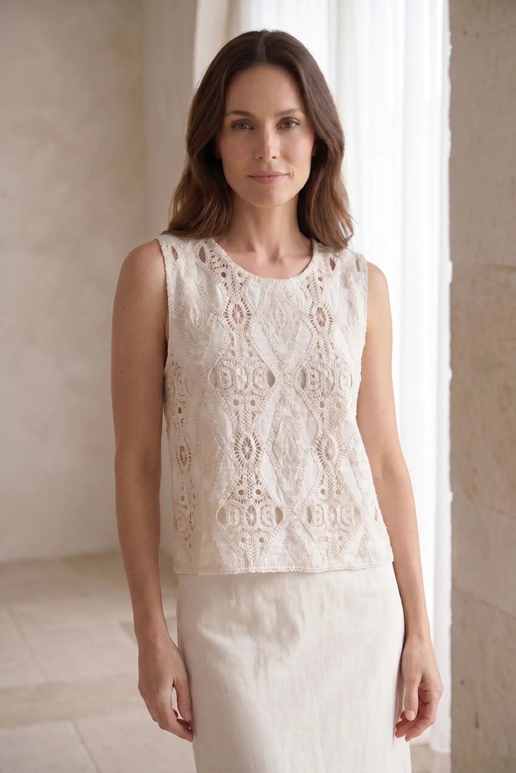 Blusa sin mangas blanca con encaje geométrico, ideal para looks casuales y estilosos de mujer