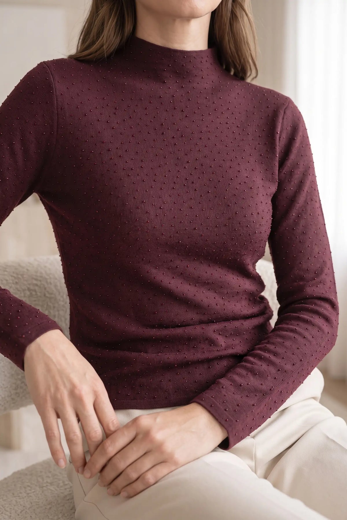 Mujer vistiendo jersey fino burdeos de cuello alto con detalles brillantes de CHICA del Sur