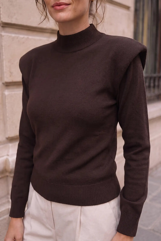 Mujer vistiendo top marrón chocolate de cuello alto y hombros estructurados de CHICA del Sur.
