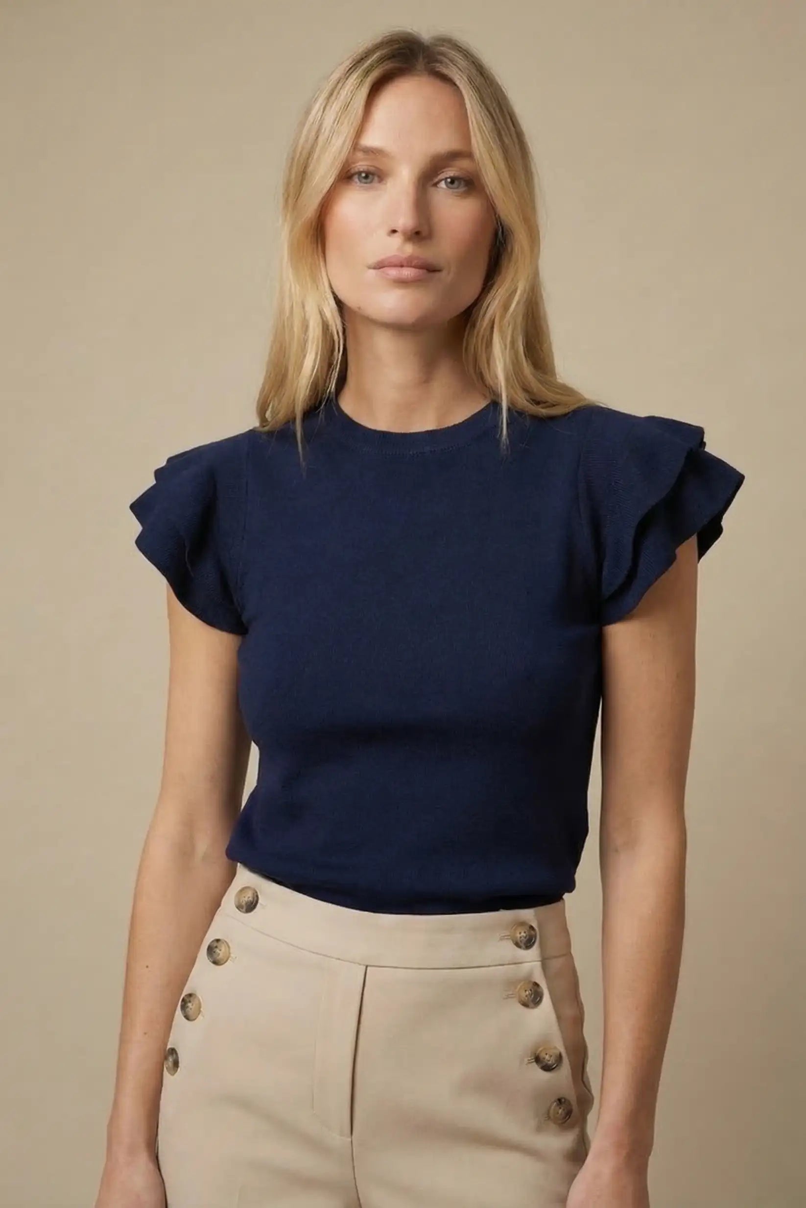 Mujer con top azul marino de manga corta con volantes, look casual y elegante de primavera