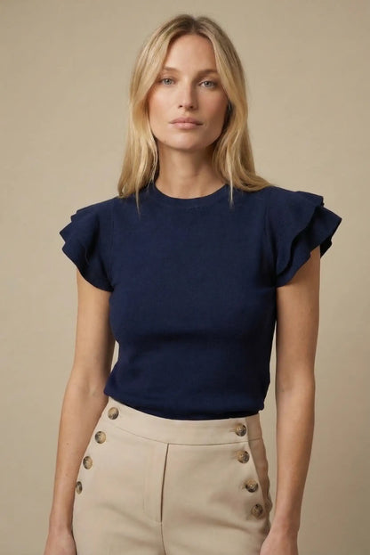 Mujer con top azul marino de manga corta con volantes, look casual y elegante de primavera