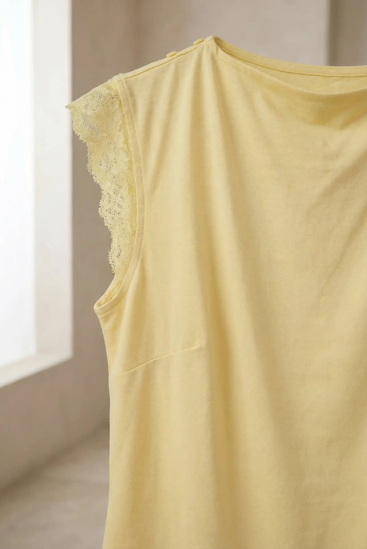 Top de mujer amarillo pastel sin mangas con detalle de encaje en el hombro