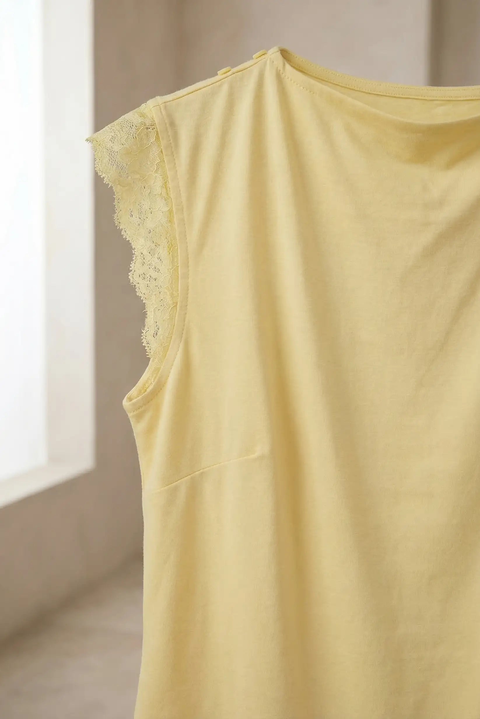 Top de mujer amarillo pastel sin mangas con detalle de encaje en el hombro