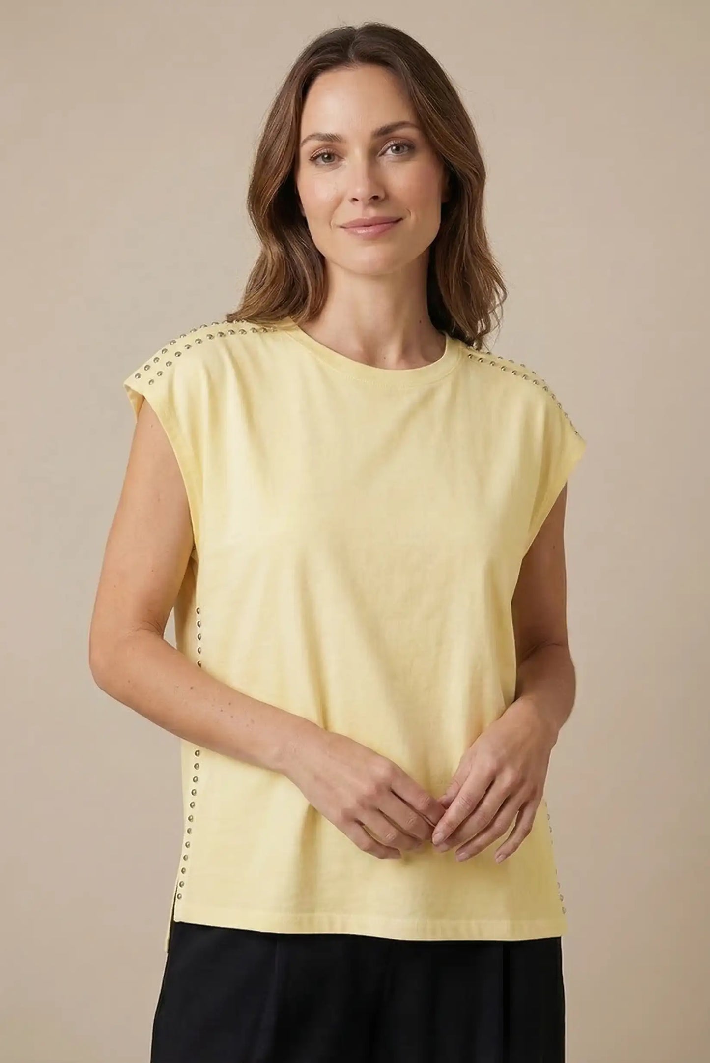Top mujer sin mangas amarillo con tachuelas en hombros, look casual femenino.