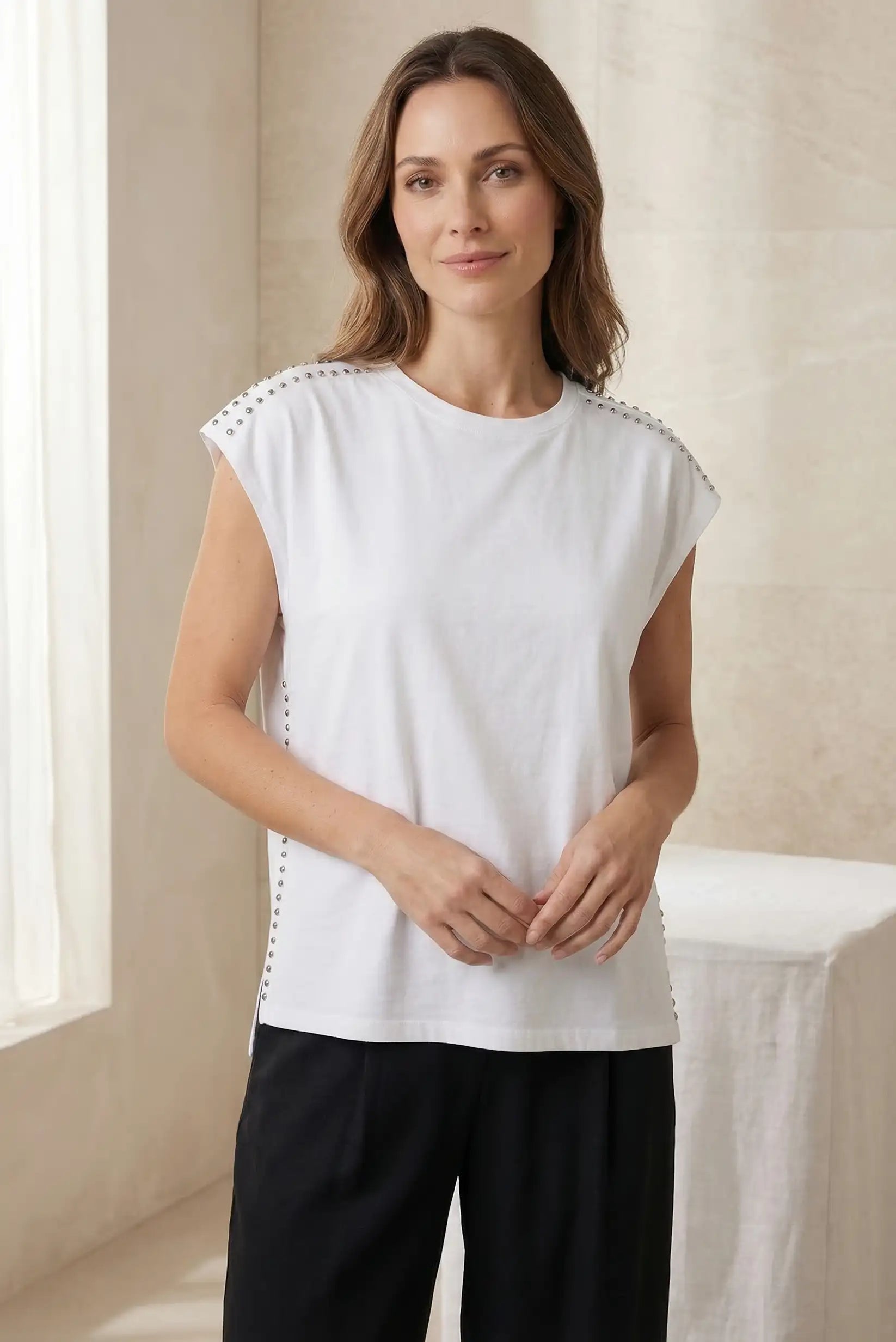 Top blanco de mujer sin mangas con tachuelas en hombros y laterales, look casual