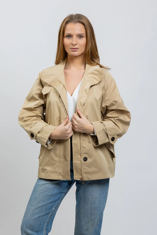 Mujer con trench cazadora beige de primavera, camisa blanca y jeans, fondo neutro