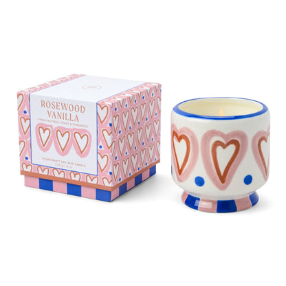 Vela aromática Paddywax Rosewood Vanilla en vaso decorado con corazones, junto a su caja rosa, ideal para CHICA del Sur.